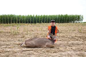 Boy with deer on ground after hunt, hunting for beginners concept.