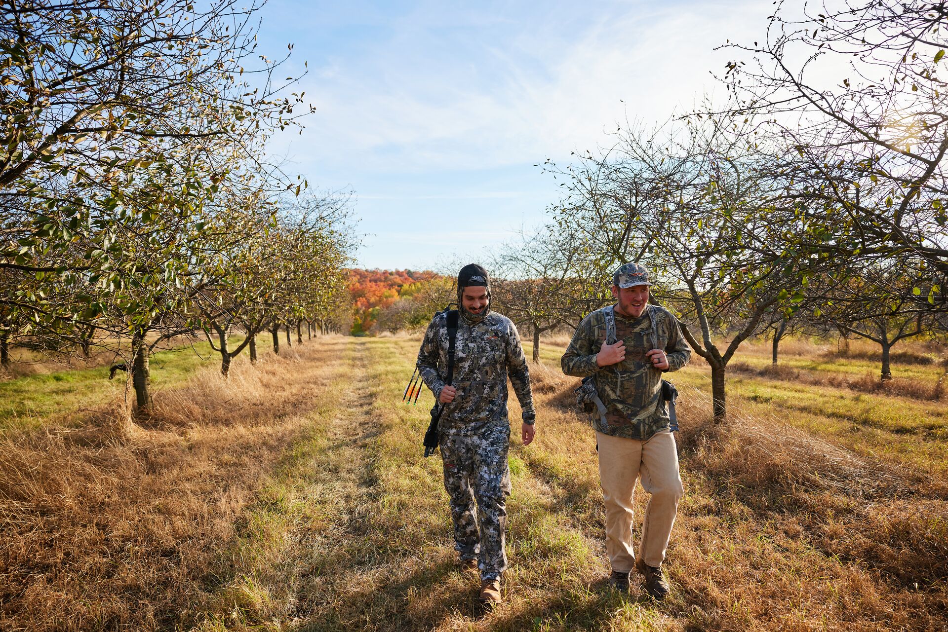 Two hunters walking on a path near trees, know Michigan hunting laws concept. 