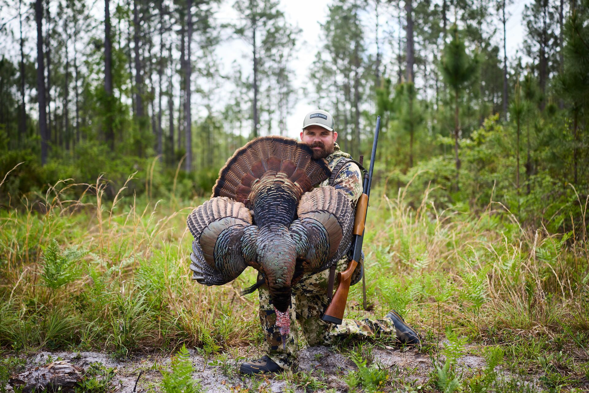 Hunter holds large turkey after hunt, Real ID TX requirement to hunt in Texas concept. 