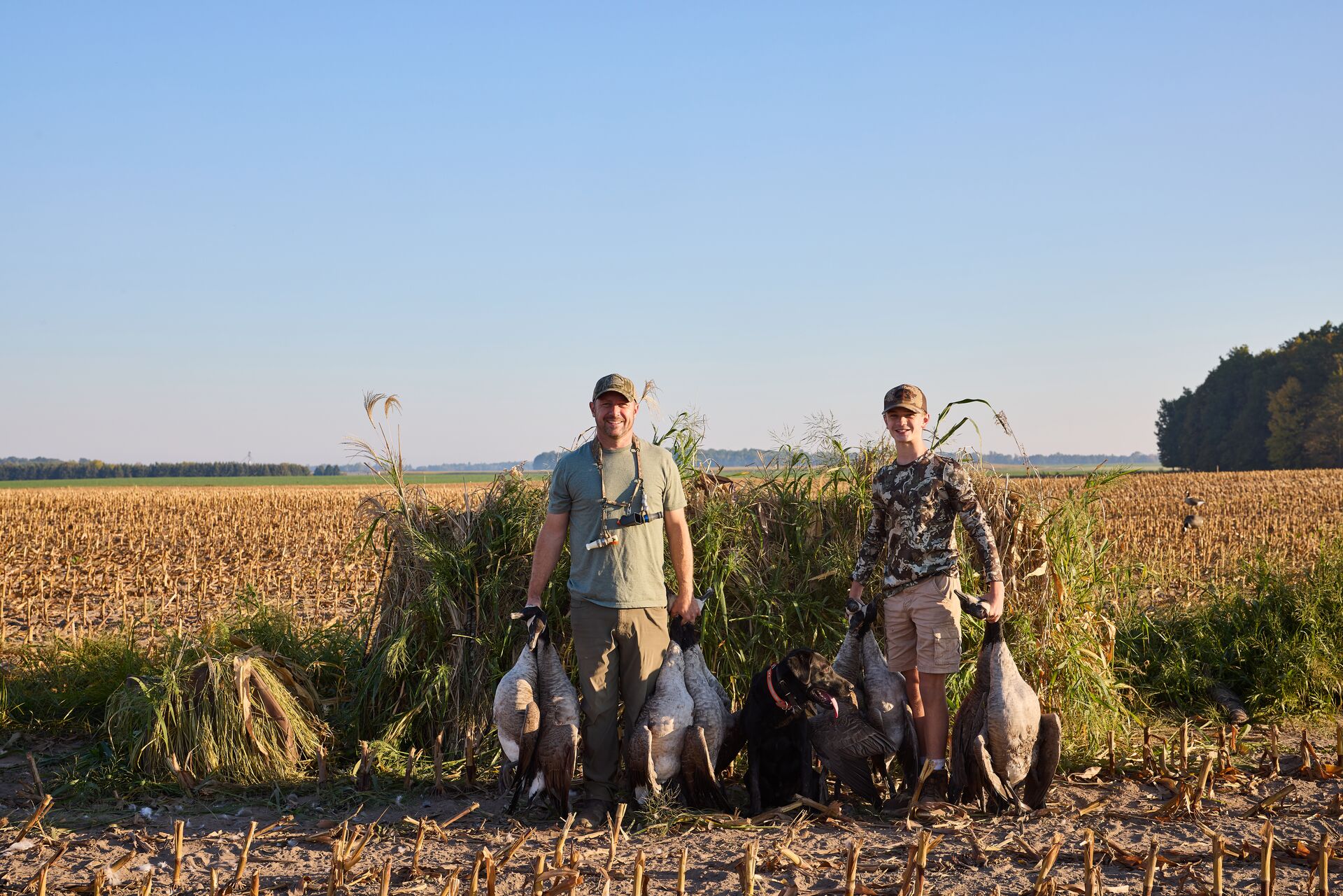 Man and boy show geese after hunt, how to get an apprentice hunting license in Indiana concept. 