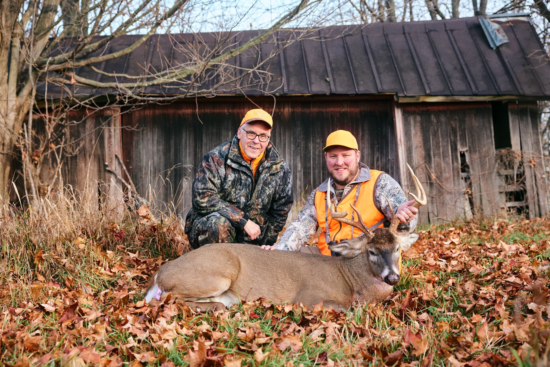 Two hunters show off a buck deer after a hunt, apprentice hunting license Virginia concept. 