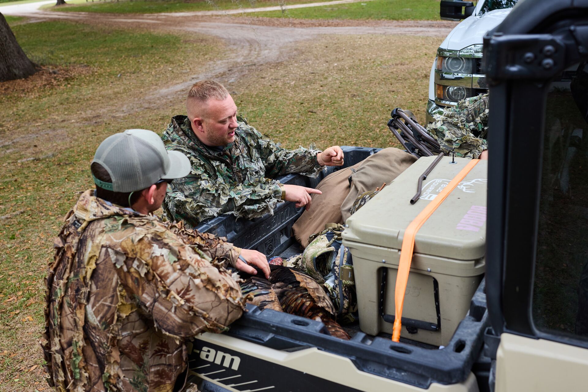Two hunters talk at the back of a truck, how to get Ohio apprentice hunting license concept. 