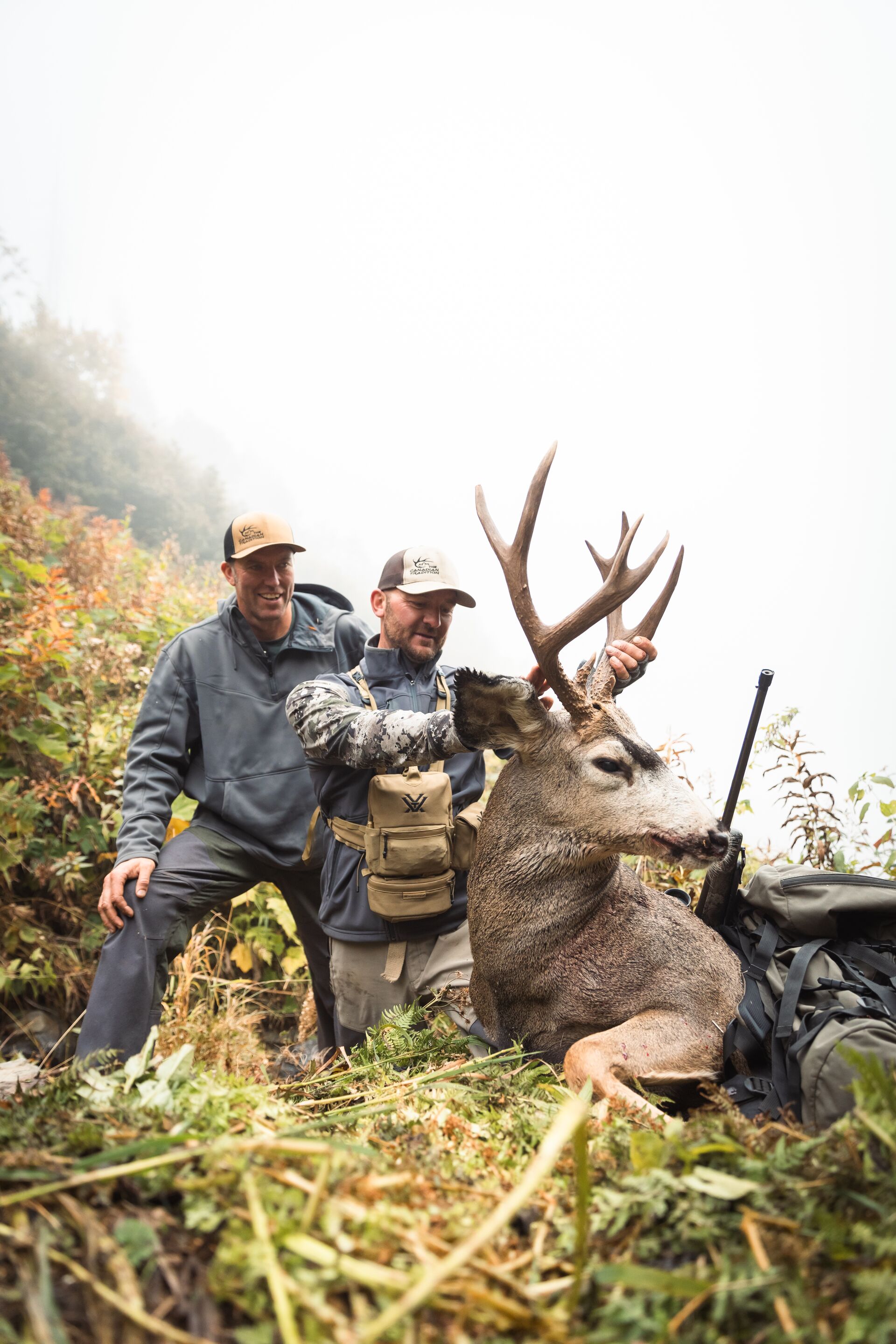 Two hunters show off mule deer after hunt, apprentice hunting license Ohio concept. 