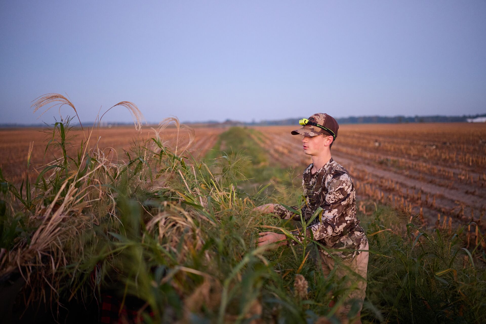 Boy stands at the edge of a field for a hunt, youth hunting license in Kentucky concept. 
