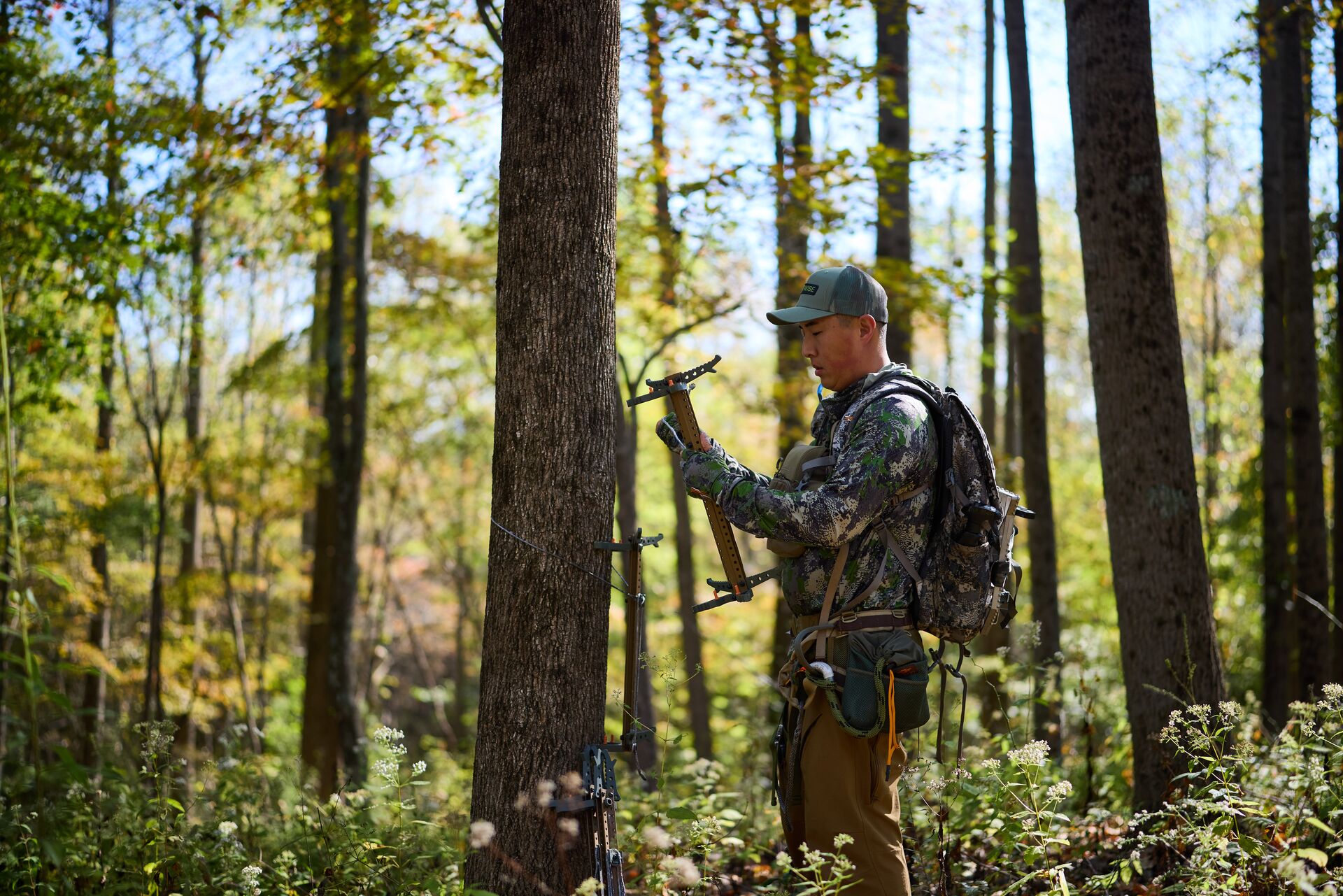 Hunter near tree gets saddle ready for hunt.