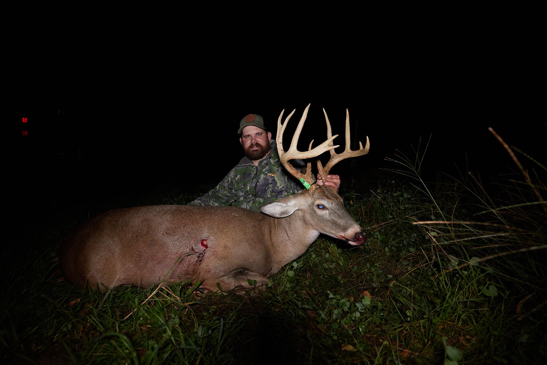 Hunter with a buck deer on the ground, do I need hunter education before deer season concept.