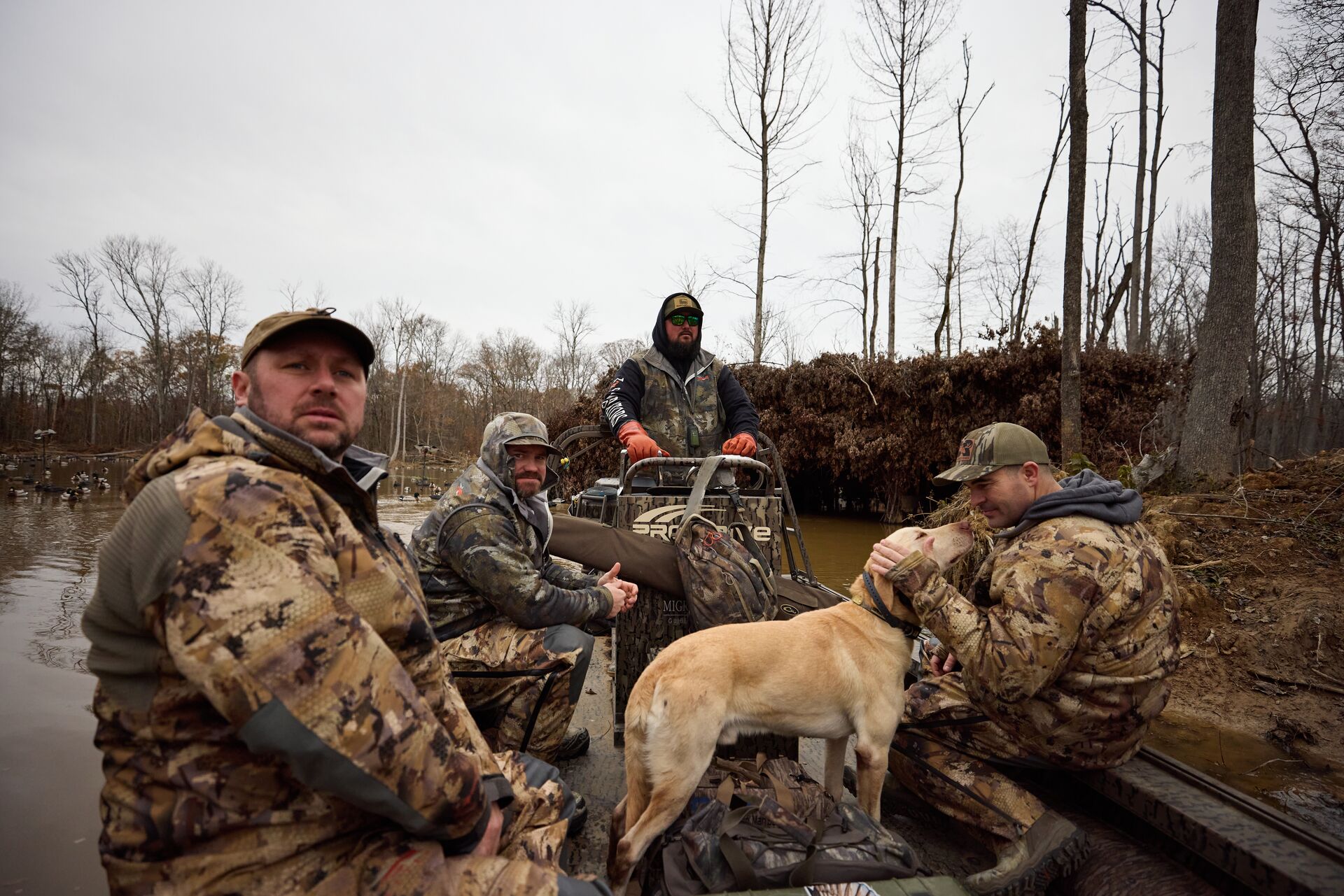Hunters in a boat with dog for waterfowl hunt, hunter safety course online concept.