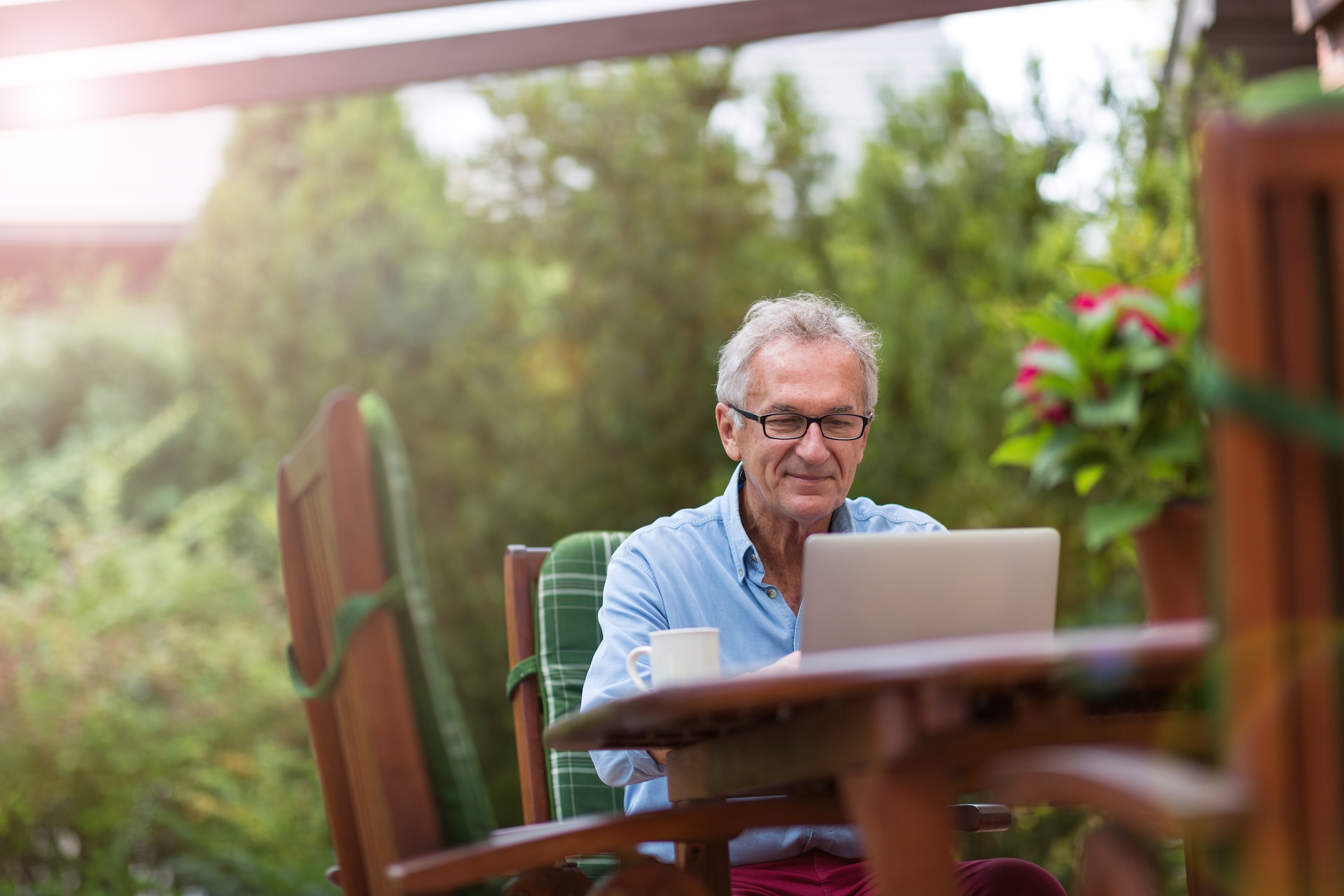 Man at a table uses a laptop, how long does an online hunter safety course take concept. 