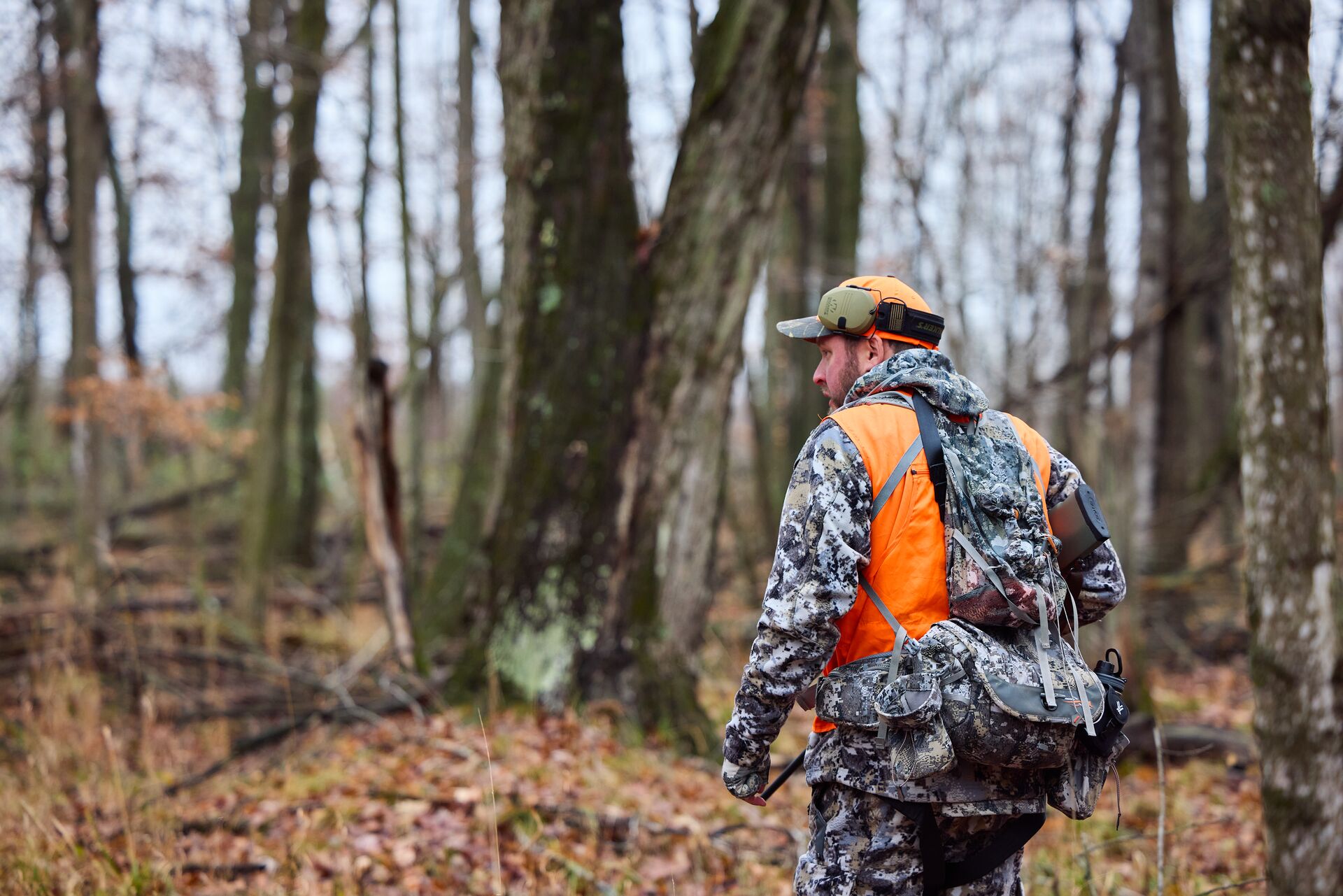 Hunter in the woods wears blaze orange, get your hunter education certificate concept. 