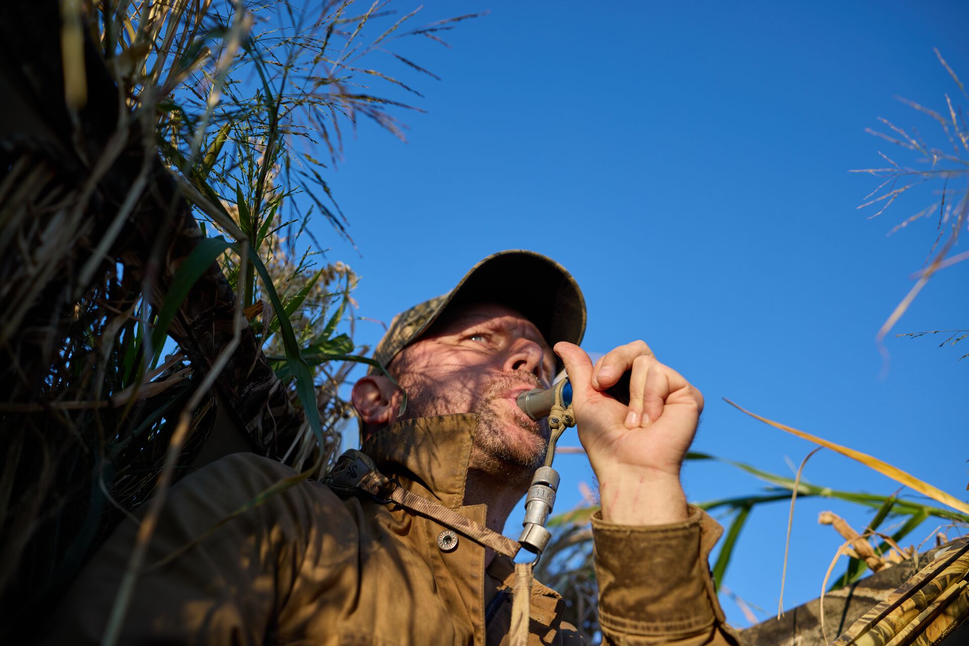 Hunter uses a duck call, complete a hunter safety course before you hunt concept. 