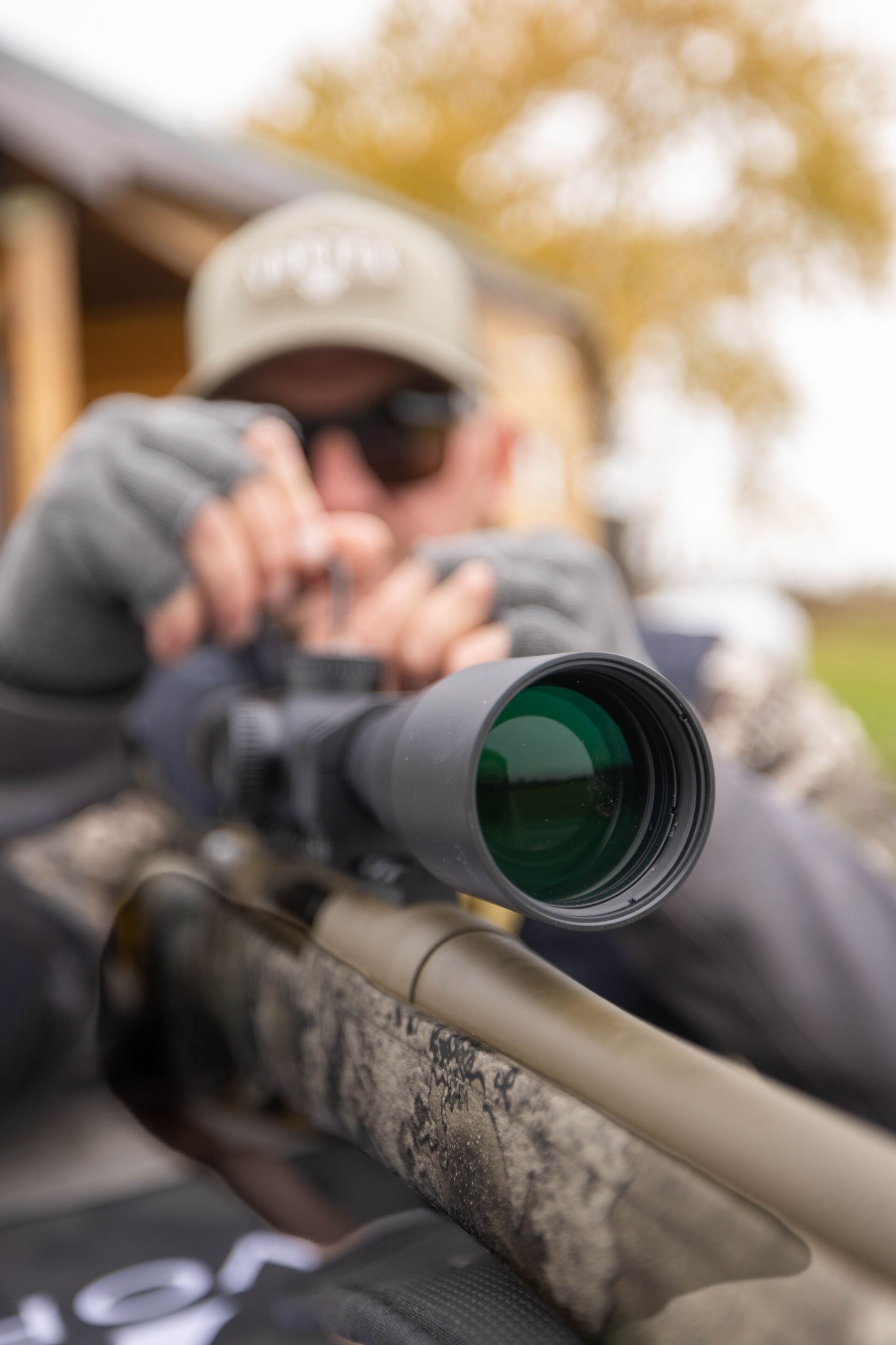 Hunter adjusts scope on rifle.