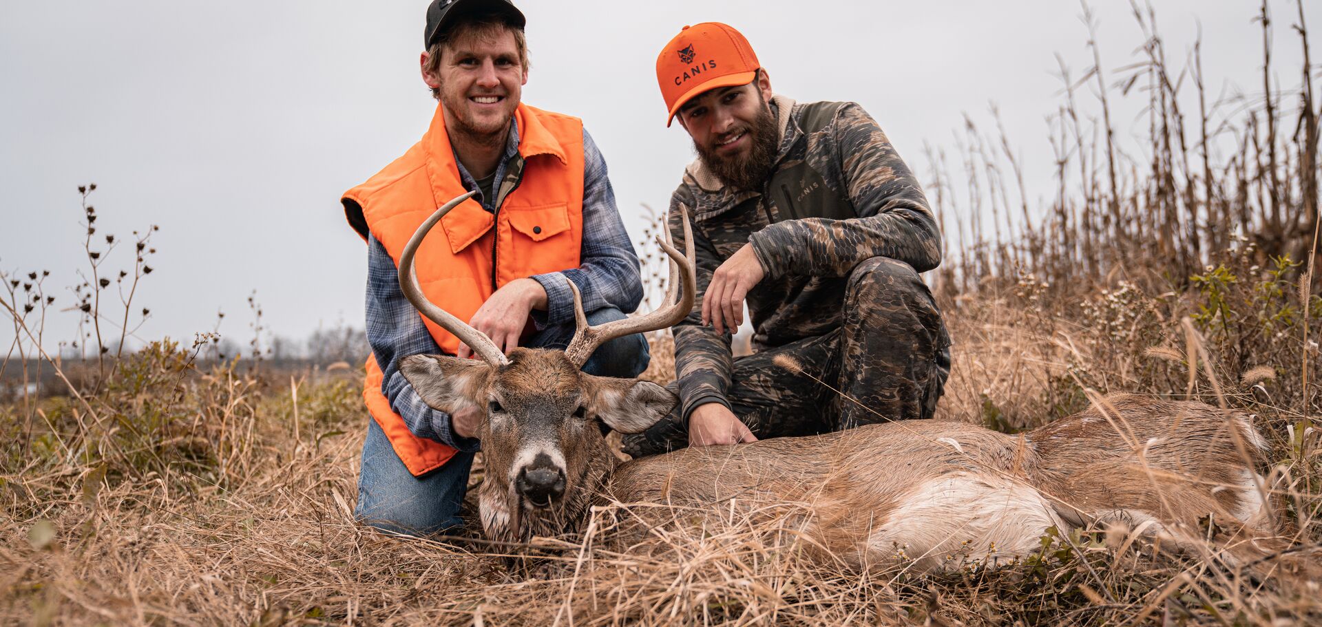 Two hunters in orange with buck deer, how much is a hunter safety course concept.