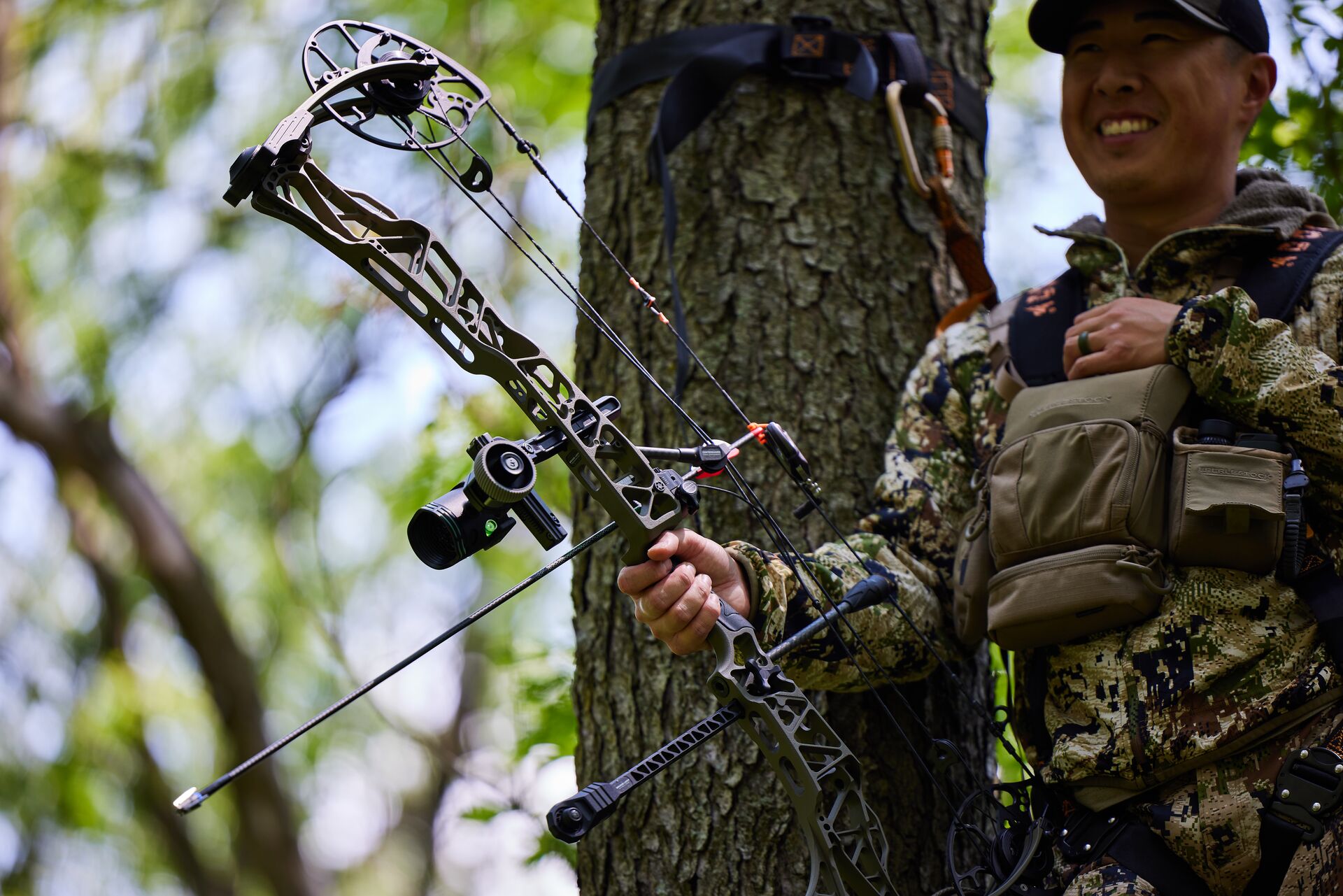 Hunter with bow smiles in tree, fastest way to get hunter certified concept.