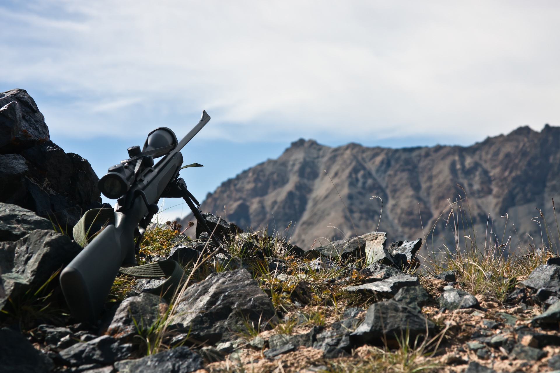 A rifle set up on a rocky ridge, long range hunting concept.