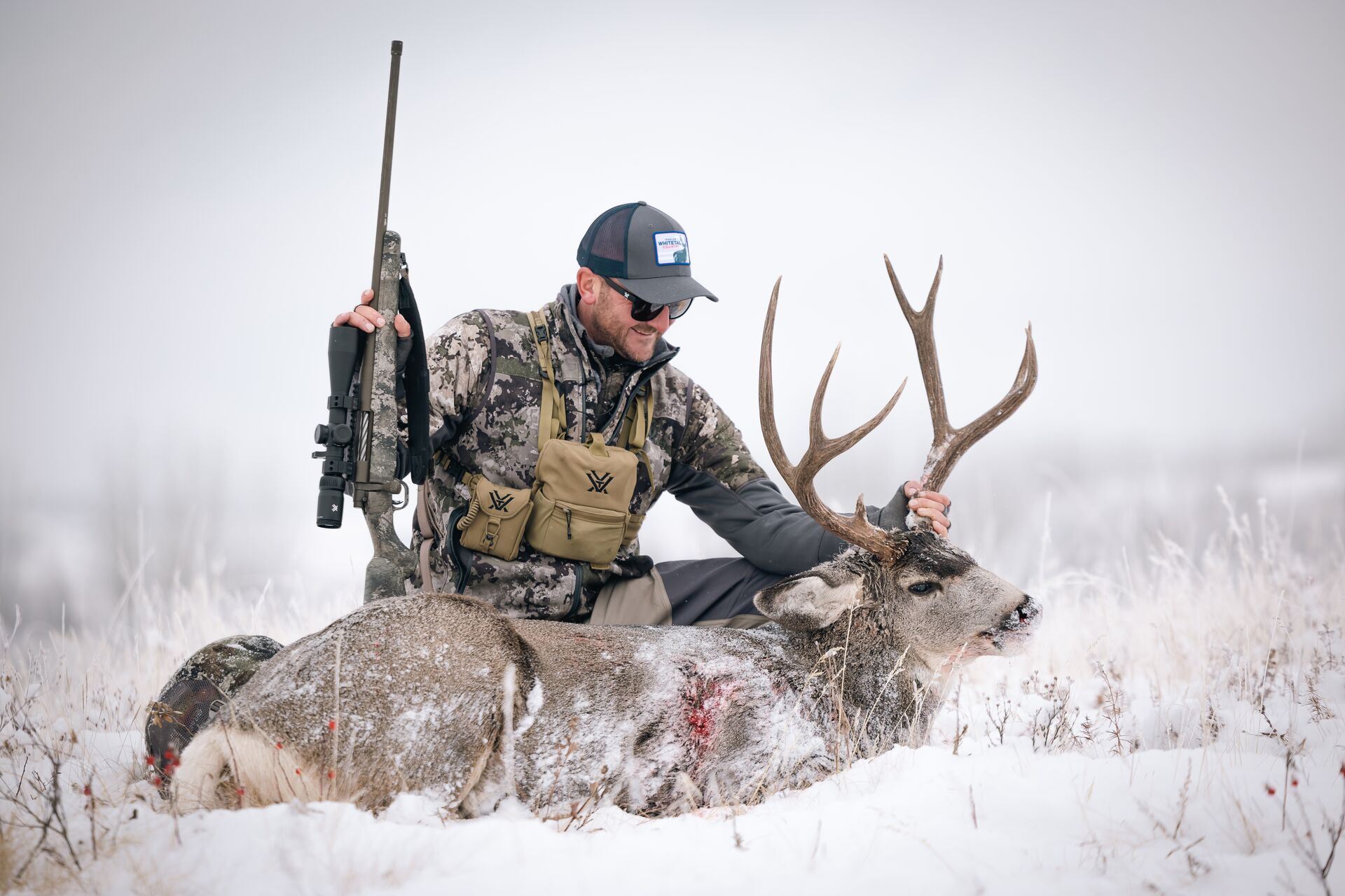 Hunter with rifle and deer in winter, flying with a rifle for out of state hunt concept.