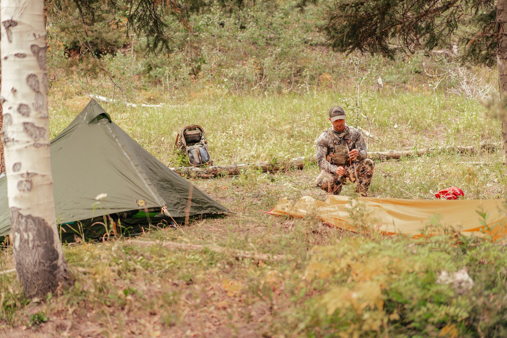 Hunter setting up camp in the woods.