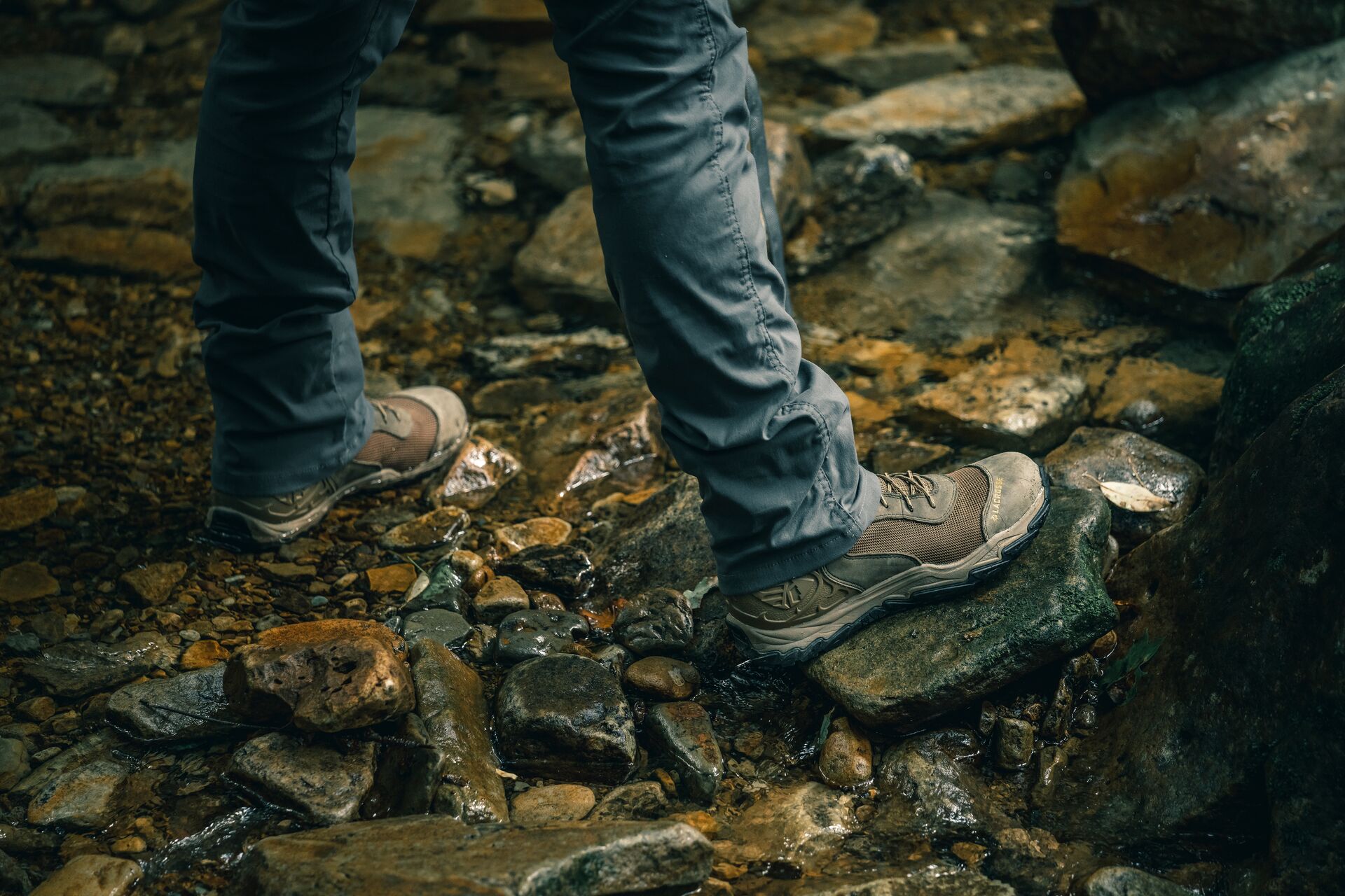 Person stands in a stream, outdoor survival tips concept.