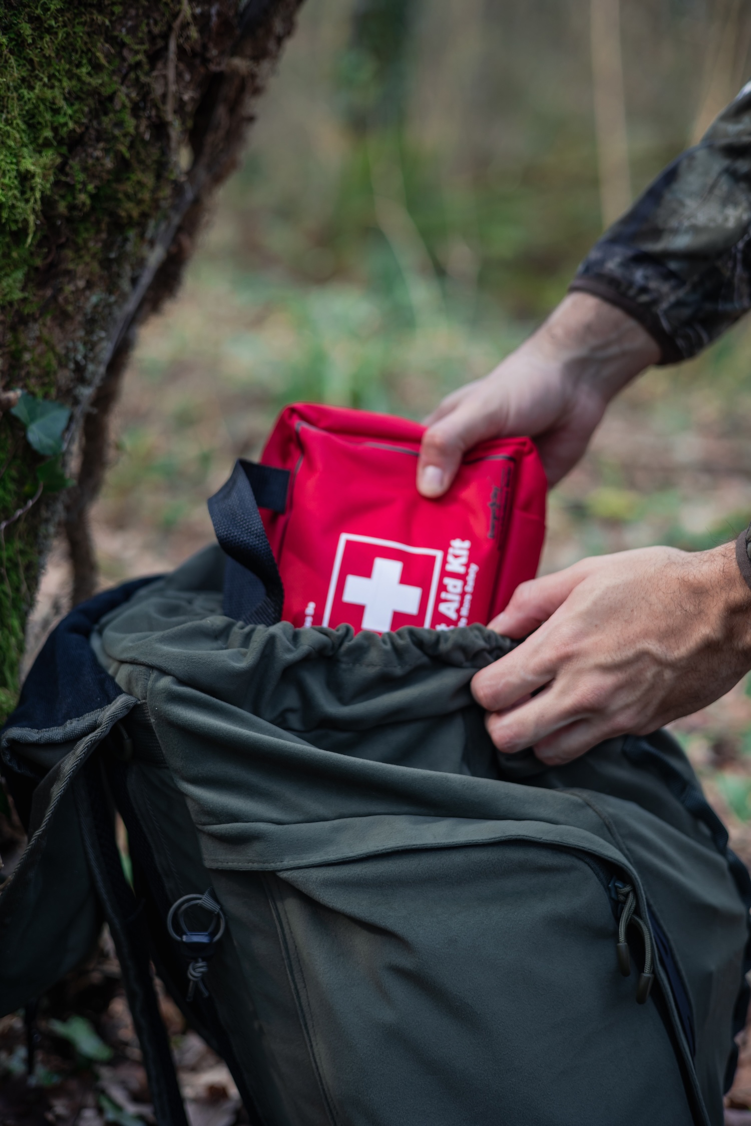 Putting a first aid kit into a backpack. 