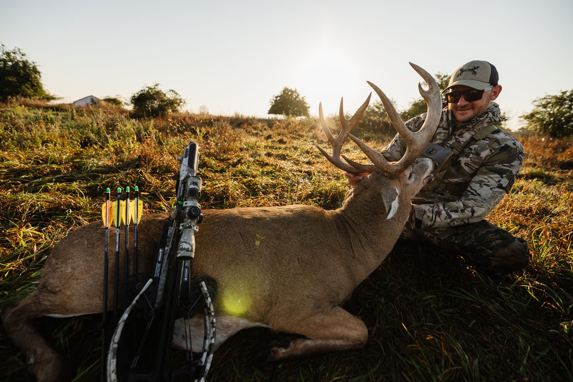 Hunter smiles with buck on the ground after hunt, hunter safety tips concept. 
