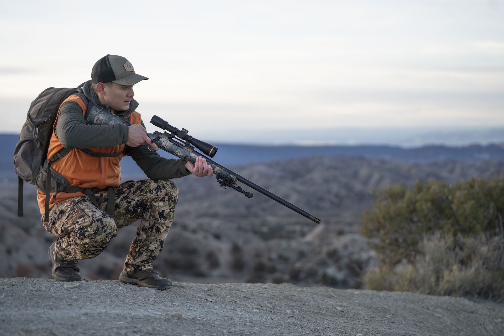 Hunter in blaze orange with a bolt action rifle. 