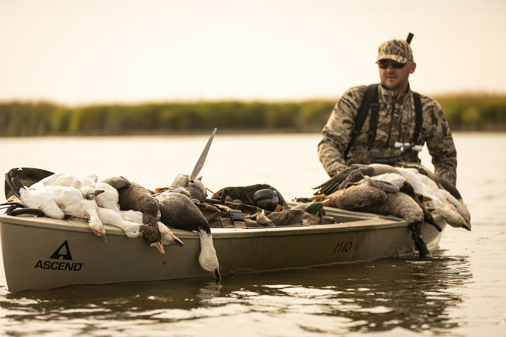 Hunter carries waterfowl in canoe after hunt, how to start hunting concept.