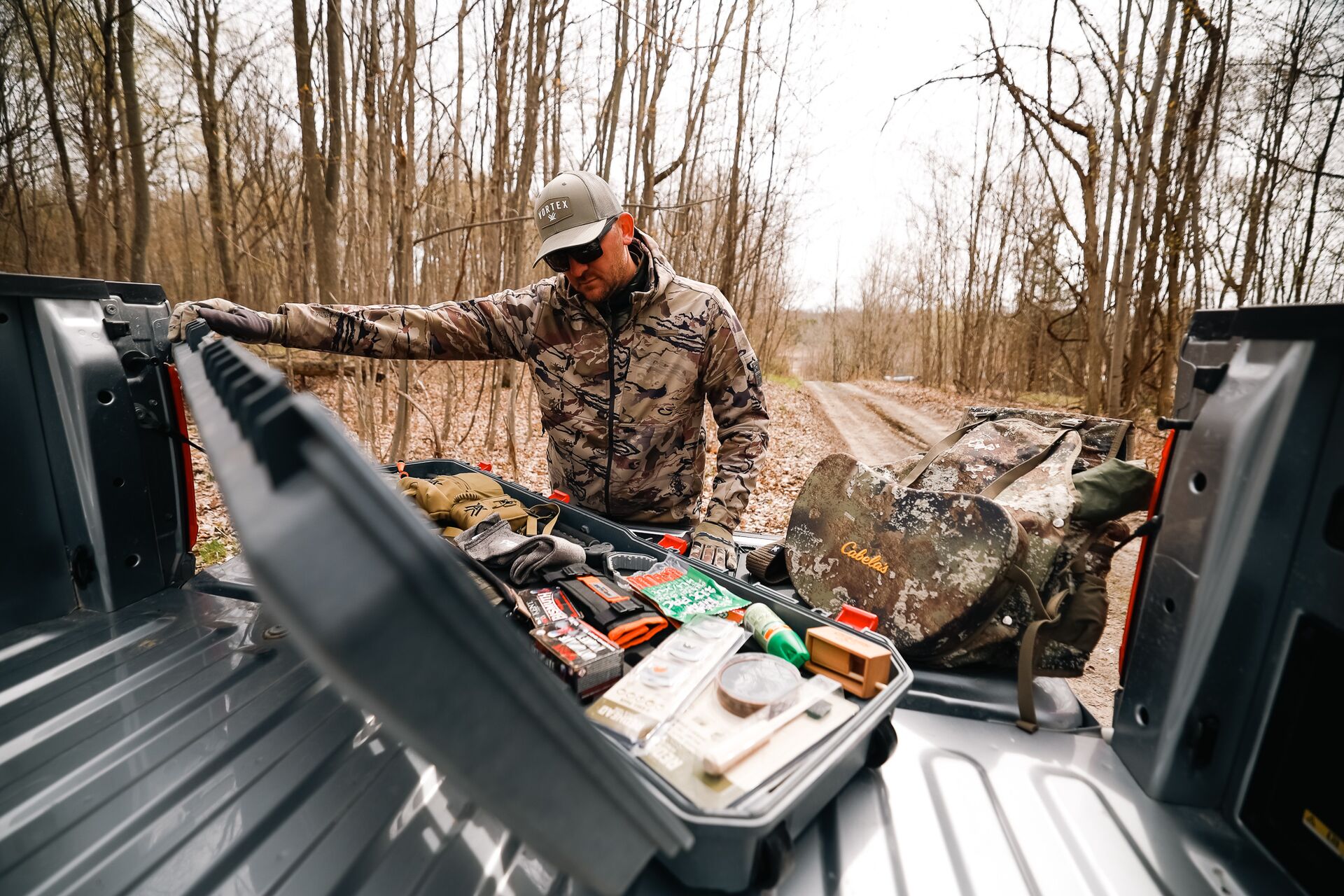 Hunter looks at gear in case in truck bed, how to start hunting concept. 