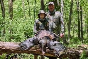 Boy and man show off turkey after hunt, how to start hunting concept.