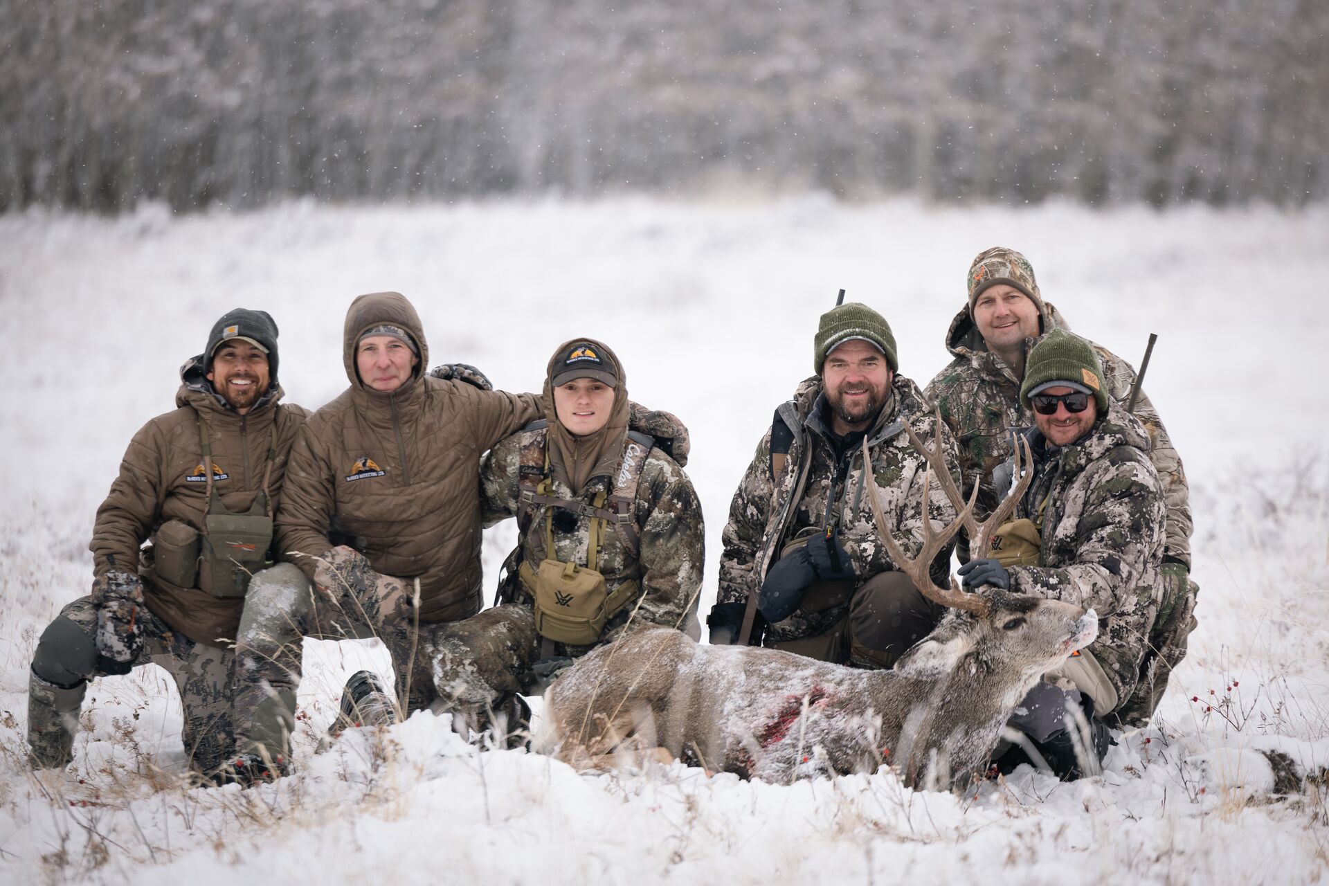 Group of hunter posing with deer after hunt in snow, hunting terminology concept.