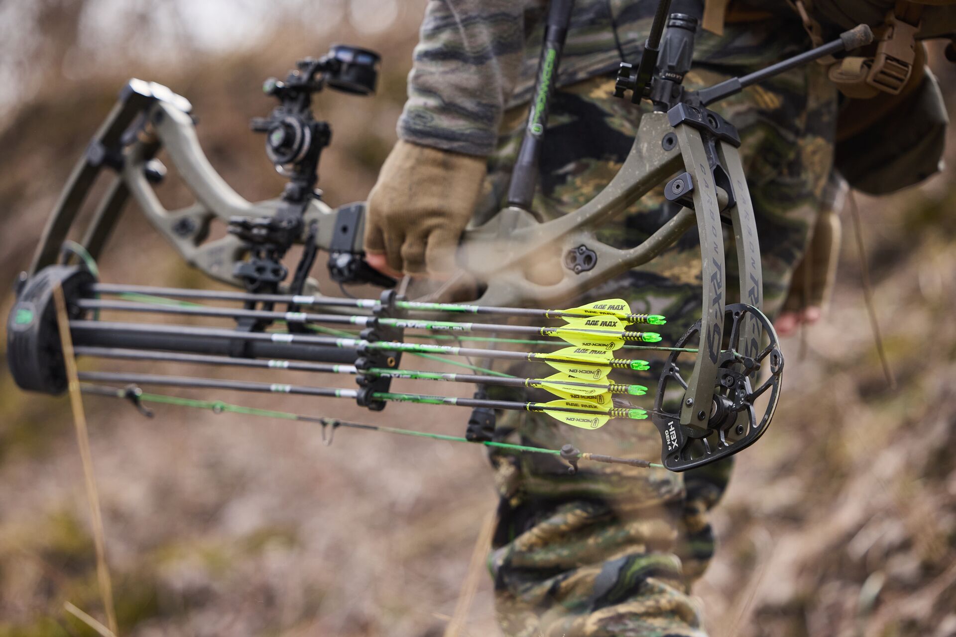 Close-up of a hunter carrying compound bow.