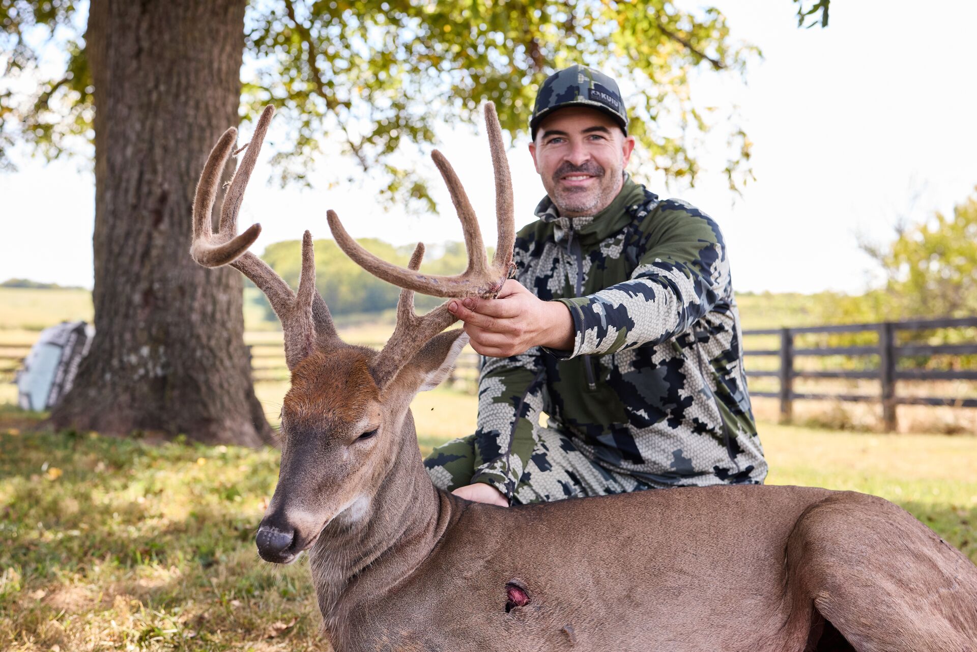 Smiling hunter with deer after hunt, deer hunting tips concept. 