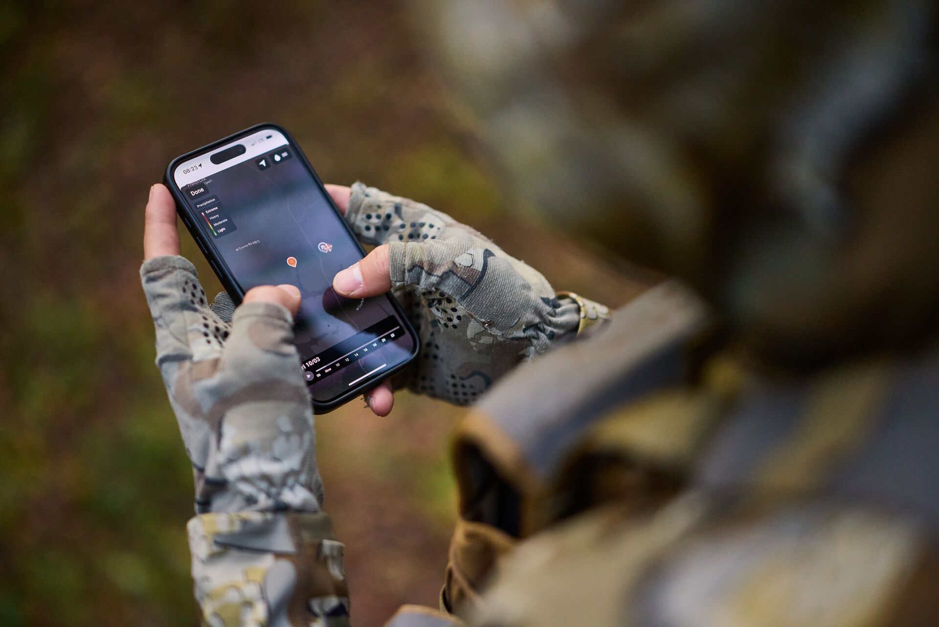 Hunter uses hunting app on phone, e-scouting for deer concept. 