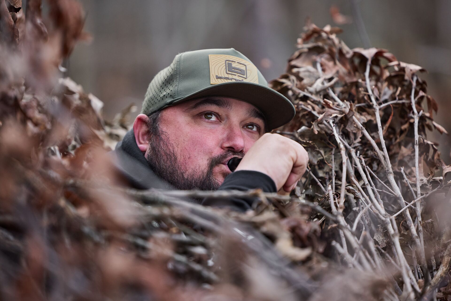 Hunter using duck call during hunt.