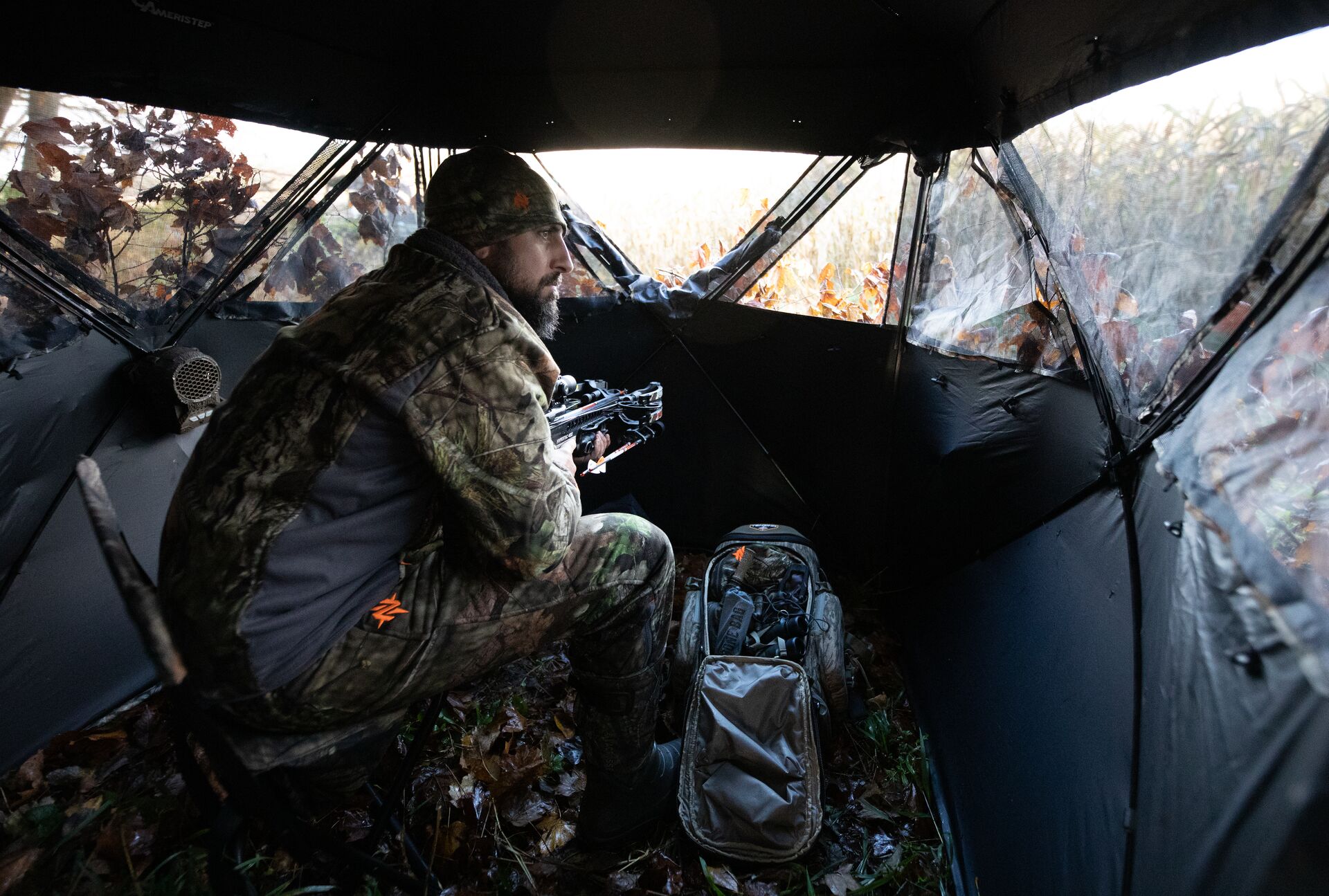 Hunter looking out from inside a hunting ground blind.