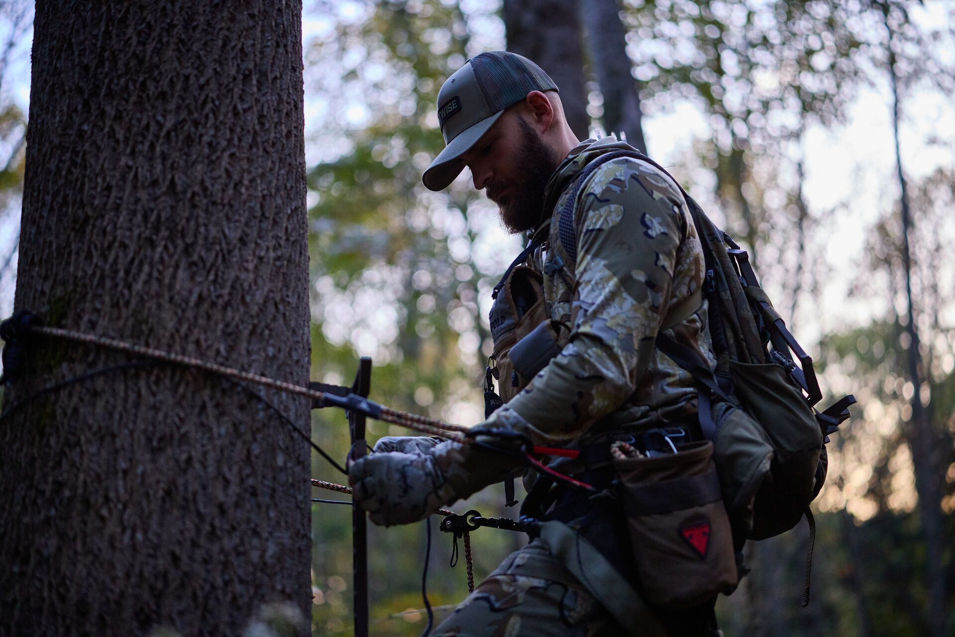 Hunter using safety system for tree saddle, hunting safety checklist concept. 